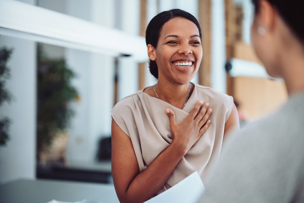 Smiling woman with hand on her heart